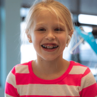 Little girl smiling, representing how to care for your braces