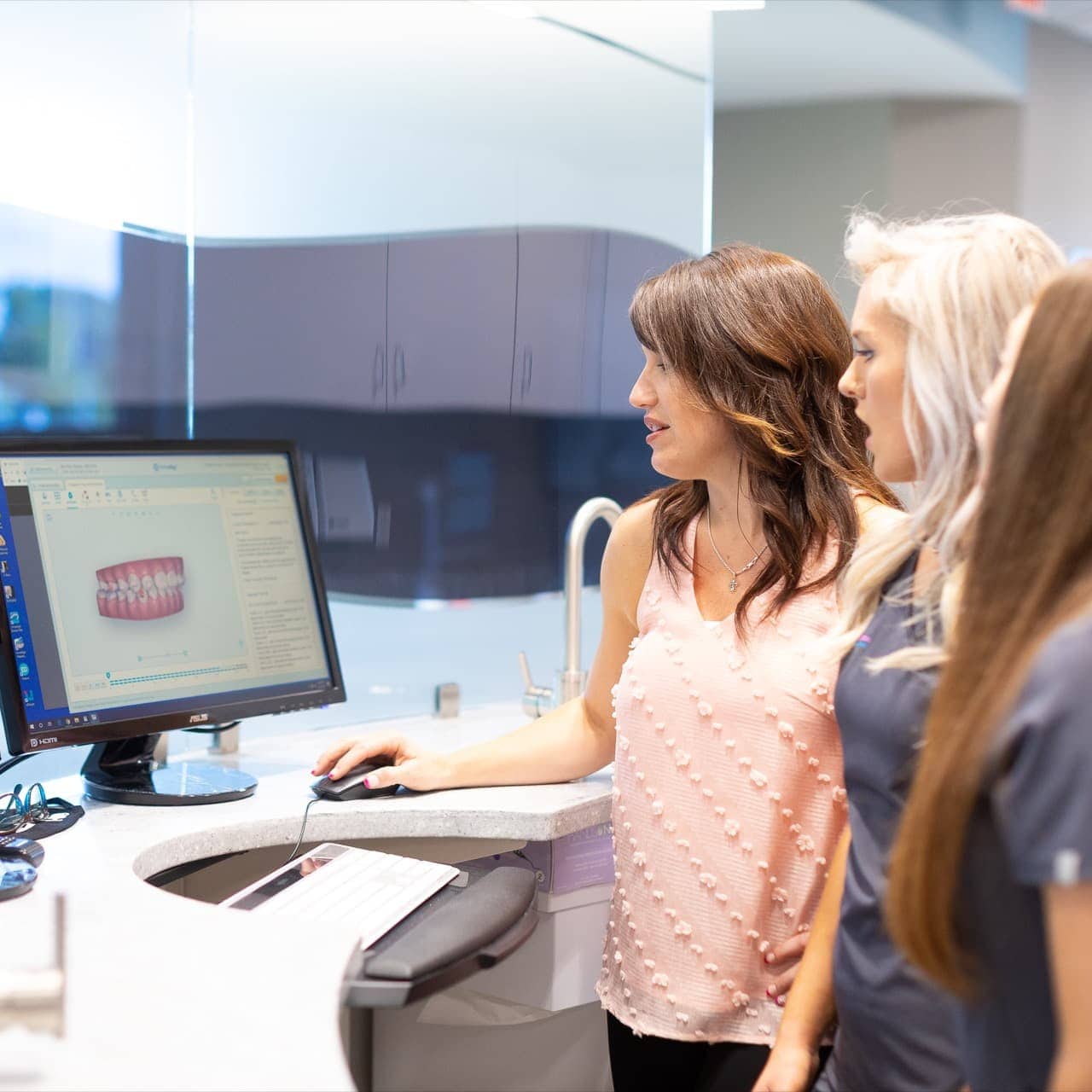 Hentscher-johnson orthodontics team members viewing a computer screen, representing advanced orthodontic treatment