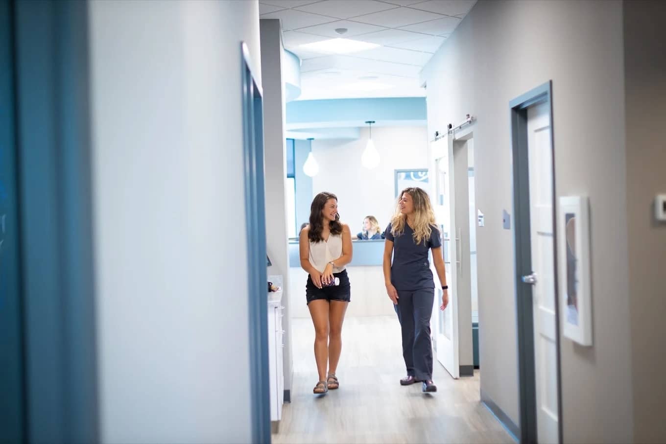 Patient walking with orthodontic team member at hentscher-johnson orthodontics in columbia, illinois.