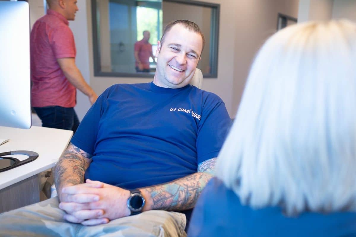 Older man smiling while sitting in the dentist chair