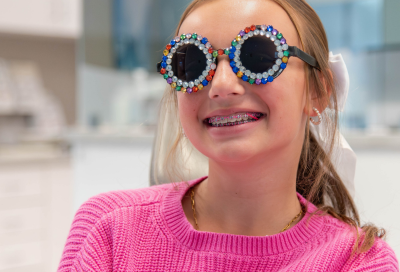 Invisalign treatment process for teens and adults 4 Teenage girl wearing pink sweater at hentscher‑johnson orthodontics, representing invisalign treatment process for teens and adults